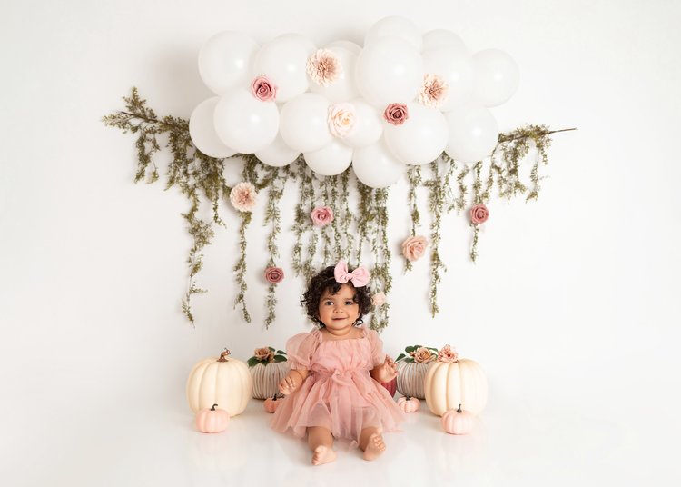 newborn posing with dress on by newborn photos by catalina